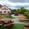 The exterior facade, signage, and beer garden seating area at The Wall's End in Wallsend, with wooden picnic tables, string lights overhead, and a TV on the wall.