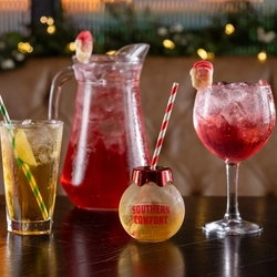 a few cocktails sitting on a wooden table of a pub