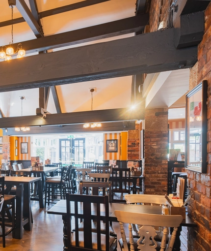 The interior restaurant seating area with fireplace and TV at The Belfry in Beighton.