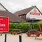 The exterior beer garden and seating area with pub signage at the Poachers.