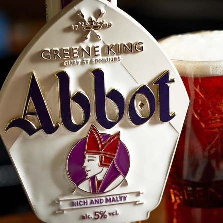 A close up of the Abbot Ale pump clip and a pint of ale