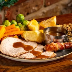 A turkey roast, served with gravy, on a table.