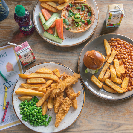 An advertising image of various young guests dishes and drinks within the interior restaurant and seating area at a Chef & Brewer venue.