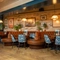 The interior restaurant seating area of the Cock & Pye, with upholstered booth seating and framed artwork on the wall.