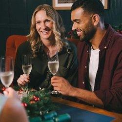 An image of 3 friends sat within the interior seating area enjoying glasses of sparkling white wine.