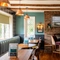 An interior restaurant seating area at The Walkford, with an upholstered booth seat in front of the leaded windows, wooden beams on the ceiling, and a brick fireplace.