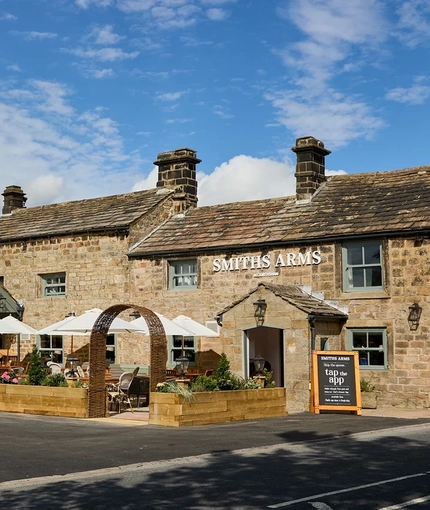 The exterior facade, signage and beer garden seating area of the Smiths Arms pub in Beckwithshaw.