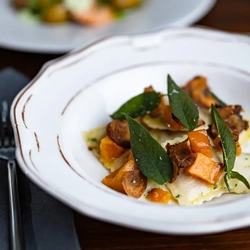 A bowl of vegetable ravioli on a table.