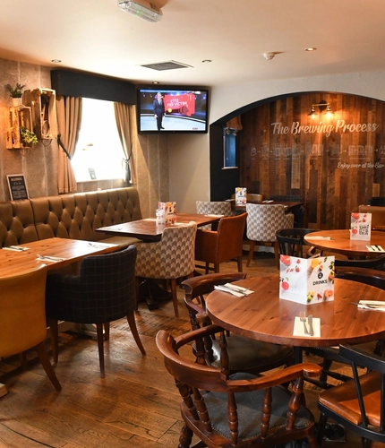 Interior dining area of a pub with a TV.