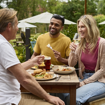 An exterior shot of people enjoying summer beers in a beer garden at a Chef & Brewer venue.