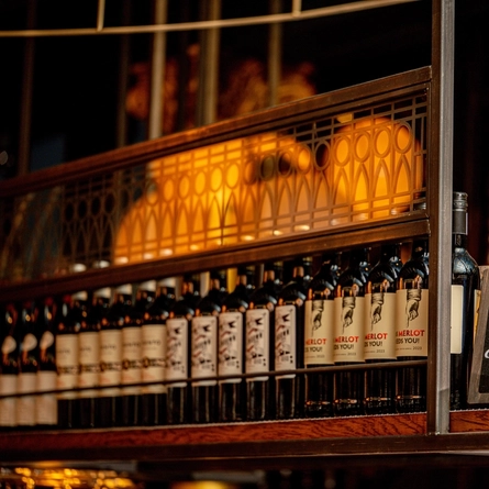 Bottles of wine and signage, on a shelf inside The Blue Posts.
