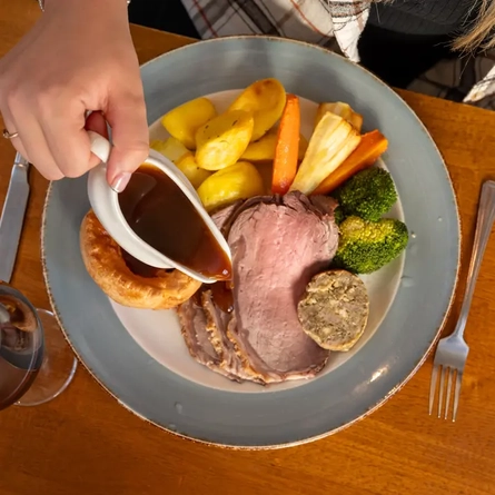 Pouring gravy over a roast dinner