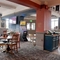 Interior dining area of a pub with a TV playing tennis.