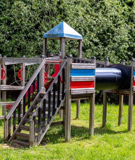 Exterior beer garden of a pub with a seating area and a play area.