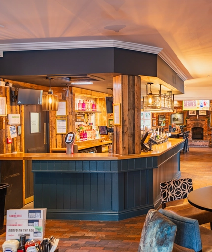 The bar and interior restaurant seating area with fireplace, TV and pub games, at The Belfry in Beighton.