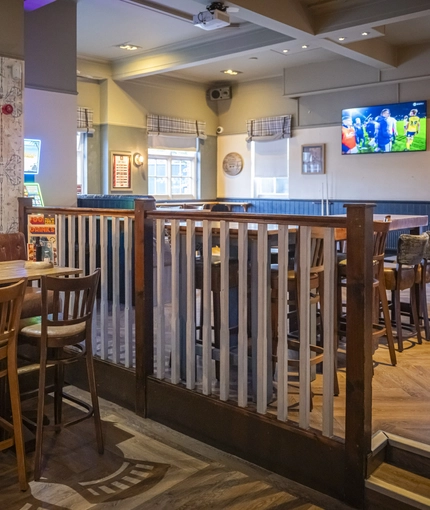 Interior dining area of a pub with a TV.