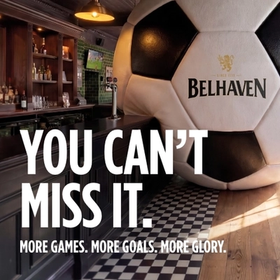A banner promoting the new football season at Belhaven venues. The banner shows an interior of a Belhaven-branded sports bar featuring a giant football-shaped wall installation beside the bar. Large white text reads “YOU CAN’T MISS IT.” with smaller text underneath stating “MORE GAMES. MORE GOALS. MORE GLORY.” A television screen showing a football match is visible in the background above beer taps and shelves of bottles.