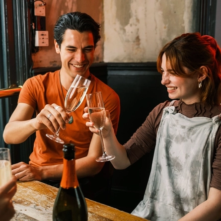 A couple toasting with two glasses of champagne.
