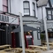 The exterior facade, signage, and seating area of The Tamar in Crownhill, with wooden picnic tables, shade umbrellas, and string lights overhead.