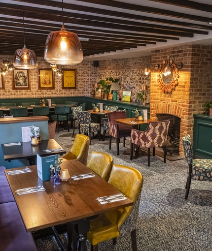 The interior restaurant and seating area with fireplace at The Bell.