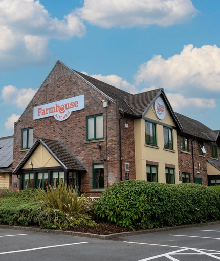 The exterior facade of the venue including venue branded signage and car park area at The Farmhouse Kitchen Willington.
