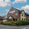 The exterior facade of the venue including venue branded signage and car park area at The Farmhouse Kitchen Willington.
