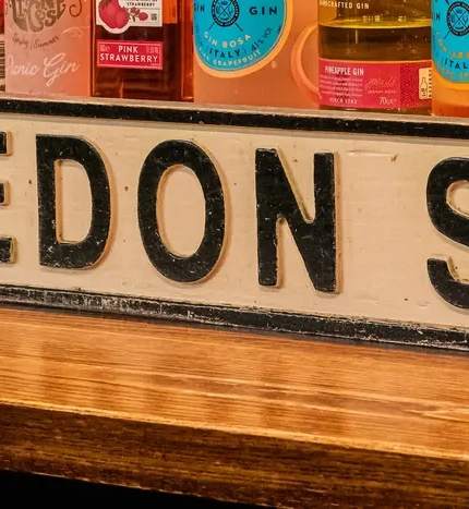 Interior bar spirits bottles behind bar with Wimbledon SW19 Street Sign