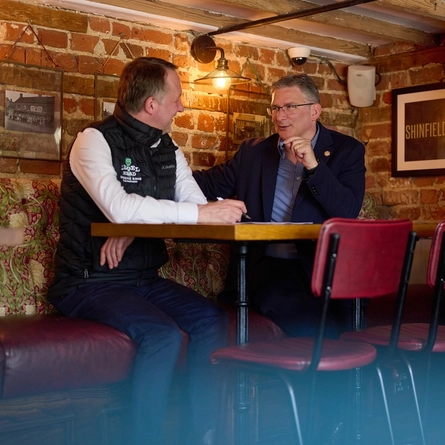 A Pub Partners image showing 2 people sat at a table within the Shinfield Arms.