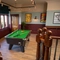 The interior games area at the Golden Hind in Cambridge, with a pool table, a large TV, and framed artwork on the walls.