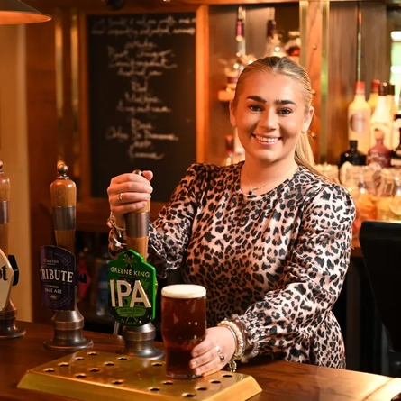 Team member pouring a pint