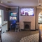 Interior bar of a pub with a seating area, a TV, a gambling machine and a fireplace.