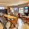 The interior restaurant seating area of The Flying Horse in Heald Green, with wooden tables, upholstered chairs, TVs on the walls and a gaming machine.