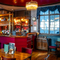 The interior restaurant seating area and small bar at the Two Chairmen, with wooden flooring, and framed artwork on the wall.