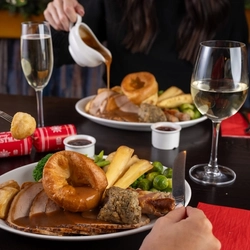 plates of food sitting on a wooden table of a pub