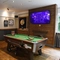 Interior dining area of a pub with a TV, a pool table and a dartboard.