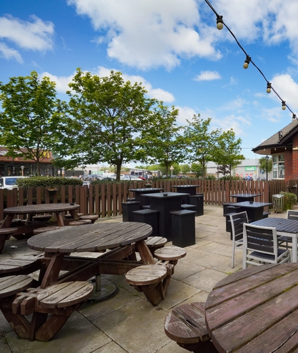 Exterior beer garden of a pub with a seating area.