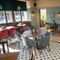 The interior restaurant seating area at the Golden Hind in Cambridge, with tiled flooring, wood panelled walls, and upholstered chairs and window seat.