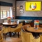 The interior restaurant seating area with tables, chairs, cushioned seating and wall mounted TV at The Castle View.