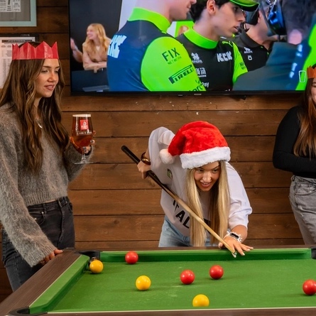 An interior shot of people celebrating Christmas in the sport/pub games area at a Flaming Grill venue.