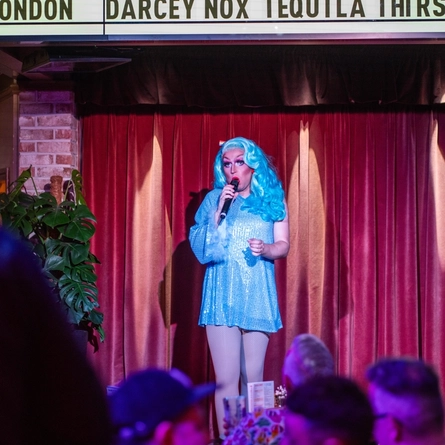 An interior image of one of the drag queen performers on the live event stage entertaining crowds during Pride Weekend at The City Of Quebec.