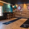 The interior games area at The Lodge in Alvaston, with two dartboards, TVs on the wall, and bar stool seating.