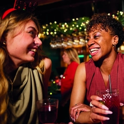 An image of people enjoying drinks within the interior of a Greene King Pub venue.