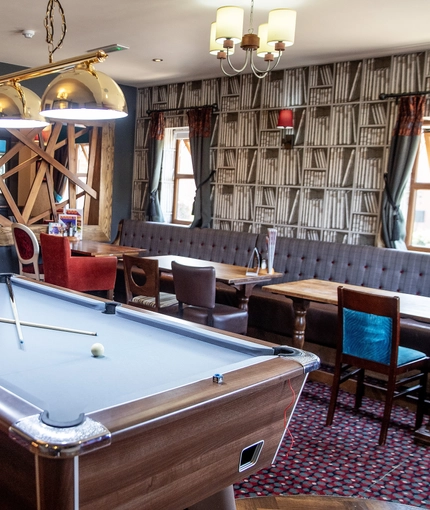 Interior dining area of a pub with a pool table.