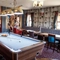 Interior dining area of a pub with a pool table.