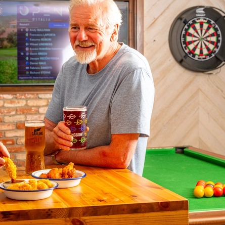 An image of 2 people enjoying a sharer snacks in a gaming area within the interior of a Hungry Horse venue.