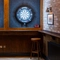 The darts area inside The Railway, with two illuminated dartboards, a small restaurant table, and a pub gaming machine.
