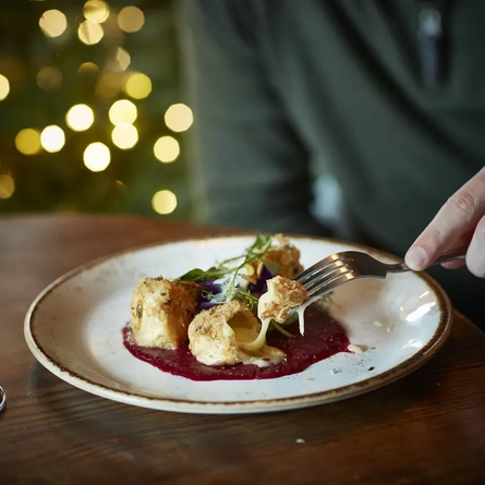 A fork digging into cheese bites.