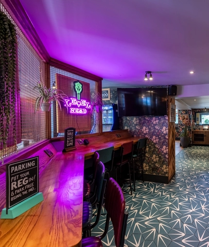 Interior dining area of a pub with a TV.