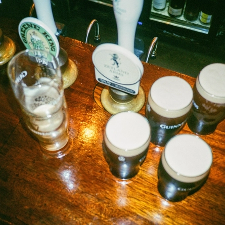 A images taken of 4 pints of Guinness and other beers from a birdseye view of the bar in a Greene King London venue.