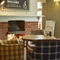 A table next to a fireplace in the seating area of the Dartbridge.